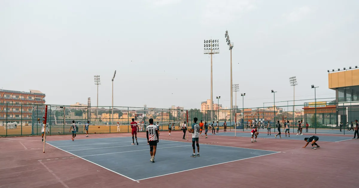 Jugadores practicando voleibol en una pista durante una sesion de entrenamiento.